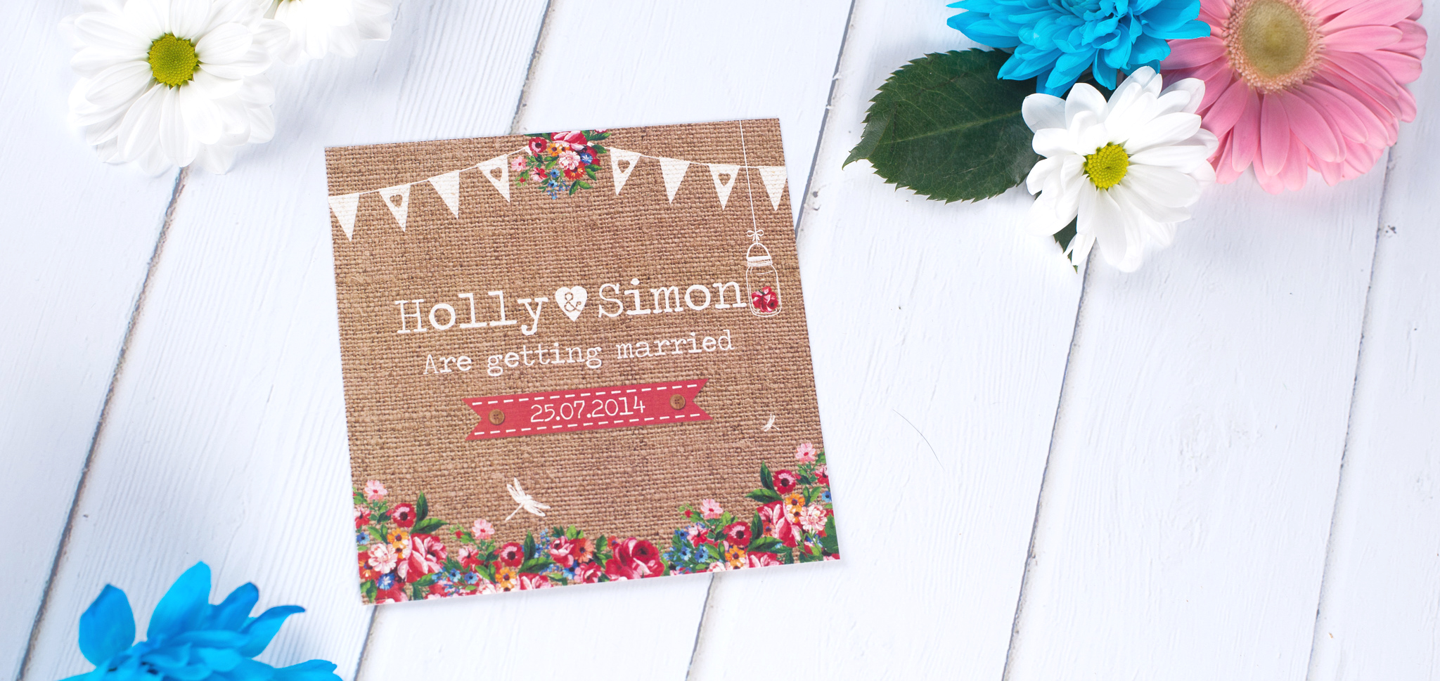 A hessian wedding invitatIon with bunting, mason jars and flowers