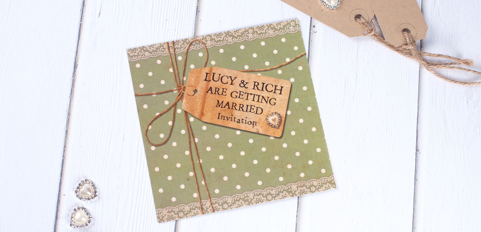 A sage green wedding invite with a vintage style, polka dots, lace, brown luggage tags and lace